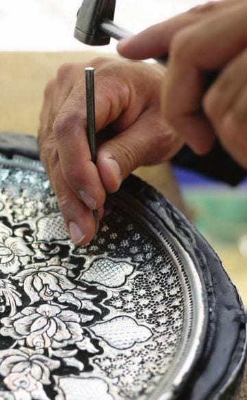 هنرمند در حال قلمزنی روی سینی مسی